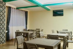 a dining room with tables and chairs and a blue ceiling at Mol Mot Hotel in Gulu