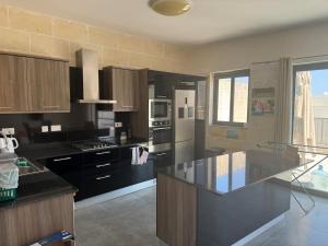 a kitchen with a black counter top and a refrigerator at Sea Views Penthouse Apartment in Xagħra