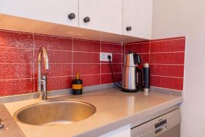 a kitchen counter with a sink and red tiles at Nar Suites Alacati in Çeşme +13 photos
