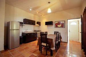 a kitchen with a table and a stainless steel refrigerator at La Ilusión Hotel Campestre y Balneario in Parras de la Fuente