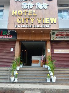 a hotel city view with potted plants in front of a building at Hotel City View in Golāghāt