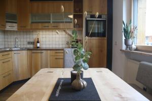 a kitchen with a wooden table with a vase on it at Sonnseite in Punschern in Teisendorf