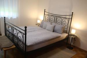 a bedroom with a black bed with white sheets and pillows at Sonnseite in Punschern in Teisendorf