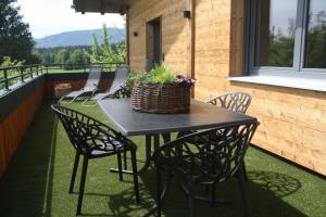a table with chairs and a basket on a balcony at Sonnseite in Punschern in Teisendorf