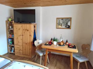 a living room with a table and a tv at Haus Wimbachtal in Ramsau