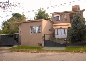 a house with a fence in front of it at La Moderna in La Falda +6 photos