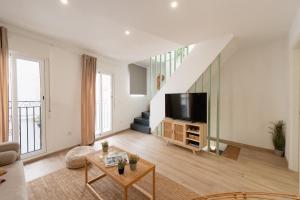 a living room with a tv and a staircase at Baélia Casa Serena in San Rafael