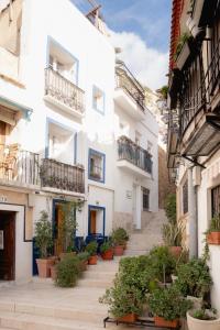 a group of white buildings with potted plants at Baélia Casa Serena in San Rafael