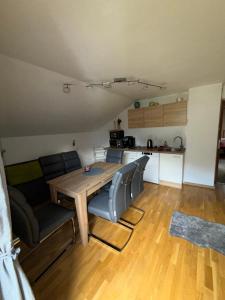 a living room with a wooden table and a kitchen at Haus Waldfrieden in Sautens