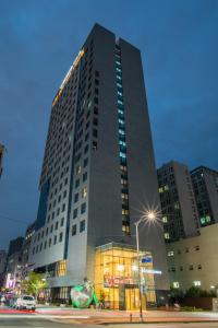 首爾的住宿－東大門IBC酒店，一座高大的建筑,前面有灯