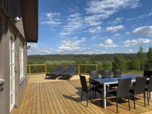 a patio with a table and chairs on a deck at Backahöjd Holidays in Rävlanda