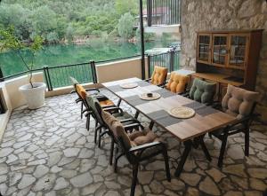 a dining room with a table and chairs and a large window at Skadar Lake Hideaway in Karuč