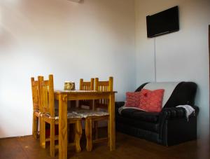 a living room with a table and a couch at La Moderna in La Falda