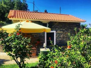 a small house with an umbrella in front of it at Vrakades - Guest House in Kouniádhoi