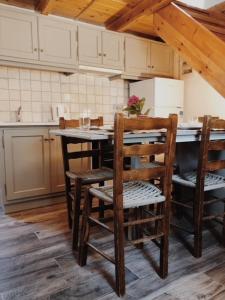 a kitchen with a table with chairs and a refrigerator at Vrakades - Guest House in Kouniádhoi