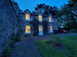 an old stone house with its lights on at Newbyth Garden Cottage in East Linton