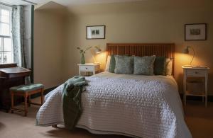 a bedroom with a large bed and a desk at Newbyth Garden Cottage in East Linton