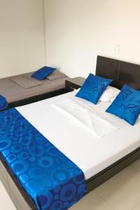 two beds in a room with blue pillows on them at Hotel Perla Azul Girardot in Girardot +59 photos