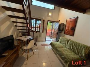 a living room with a couch and a tv and a table at Mi Casa Su Casa Lofts in Abraão