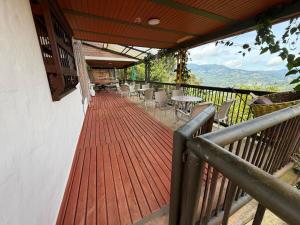a balcony with a wooden deck with tables and chairs at Villa Palosanto Campestre in Jericó +28 photos