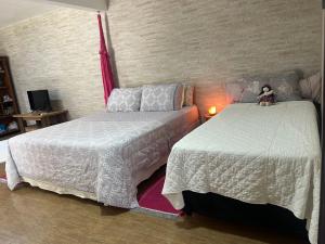 a bedroom with two beds and a teddy bear sitting on the bed at Espaço Aconchego in Pomerode