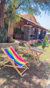 two lawn chairs and a picnic table in front of a house at Villa Rancho el piñón in Ezequiel Montes +5 photos
