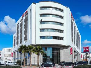 a white building with cars parked in front of it at Ibis Sfax in Sfax