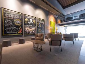 a restaurant with tables and chairs and a menu on the wall at Novotel Curitiba Batel in Curitiba