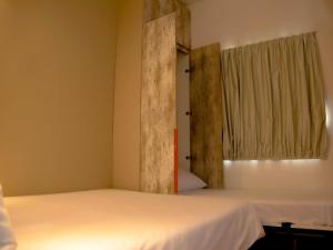 a bedroom with two beds and a window at Ibis Budget Lorena - Circuito da Fé in Lorena +72 photos