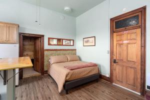a bedroom with a bed and a wooden door at Del Norte Colorado Stone Quarry Studio Apt in Del Norte