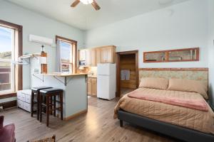 a small bedroom with a bed and a kitchen at Del Norte Colorado Stone Quarry Studio Apt in Del Norte