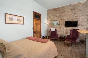 a bedroom with a bed and a stone wall at Del Norte Colorado Stone Quarry Studio Apt in Del Norte