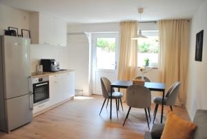 a kitchen and dining room with a table and chairs at Apartment la rosa in Weißensberg