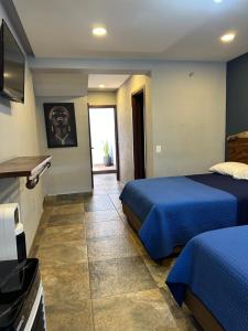 a hotel room with two beds and a television at Hotel La Bikina in Tequila