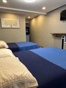 a room with two beds and a tv in it at Hotel La Bikina in Tequila +32 photos