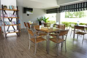 Un comedor con mesa y sillas de madera. en In Clover, en Bang Saen