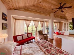 a bedroom with a red bed and a living room at Magic Mountain Views Villa in Atenas