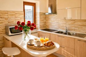 a kitchen with a table with a vase of red flowers at Casa Annalisa in Scauri
