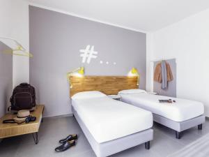 a room with two beds and a backpack at Ibis Styles Brindisi in Brindisi