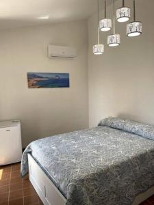 a bedroom with a bed and a painting on the wall at Casa Sciavè - Paradise in Sciacca in Sciacca