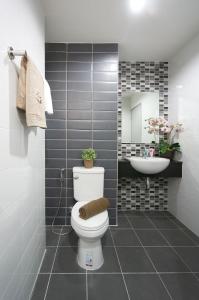 un baño con inodoro y lavabo en In Clover, en Bang Saen