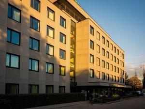 a large building with the sun shining on it at ibis Styles Budapest Citywest in Budapest