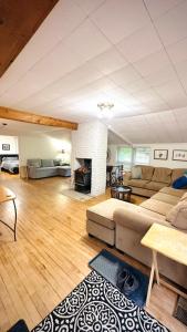 a living room with a couch and a fireplace at Falcon Retreats in Sharbot Lake