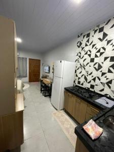 a kitchen with a white refrigerator and a table at Apartamento Açaí in Vilhena +14 photos