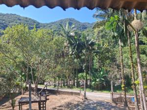 a dirt road with trees and mountains in the background at Siio do bambu in Joinville