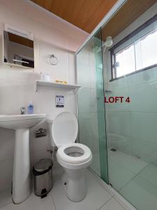 a bathroom with a toilet and a glass shower at Mi Casa Su Casa Lofts in Abraão +12 photos