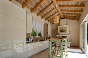 a kitchen with white cabinets and a wooden ceiling at Villa Stonica in Kringa