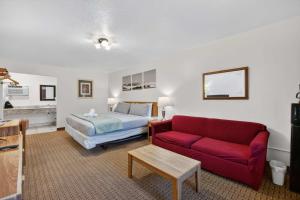 a hotel room with a bed and a red couch at Eagle Motel Suite 107 in Manitou Springs
