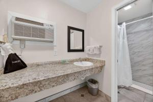 a bathroom with a sink and a microwave at Eagle Motel Suite 107 in Manitou Springs