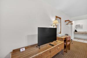 a flat screen tv sitting on top of a wooden entertainment center at Eagle Motel Suite 107 in Manitou Springs +9 photos